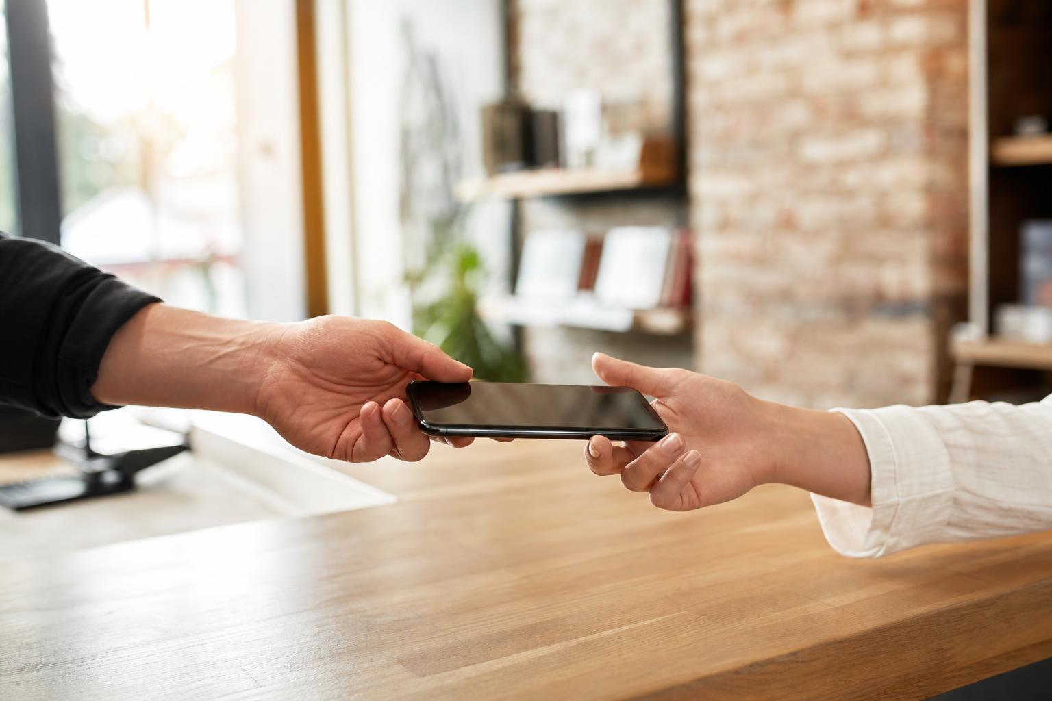 Persönliche Übergabe eines Smartphones an der FixMyTech-Theke in Köln